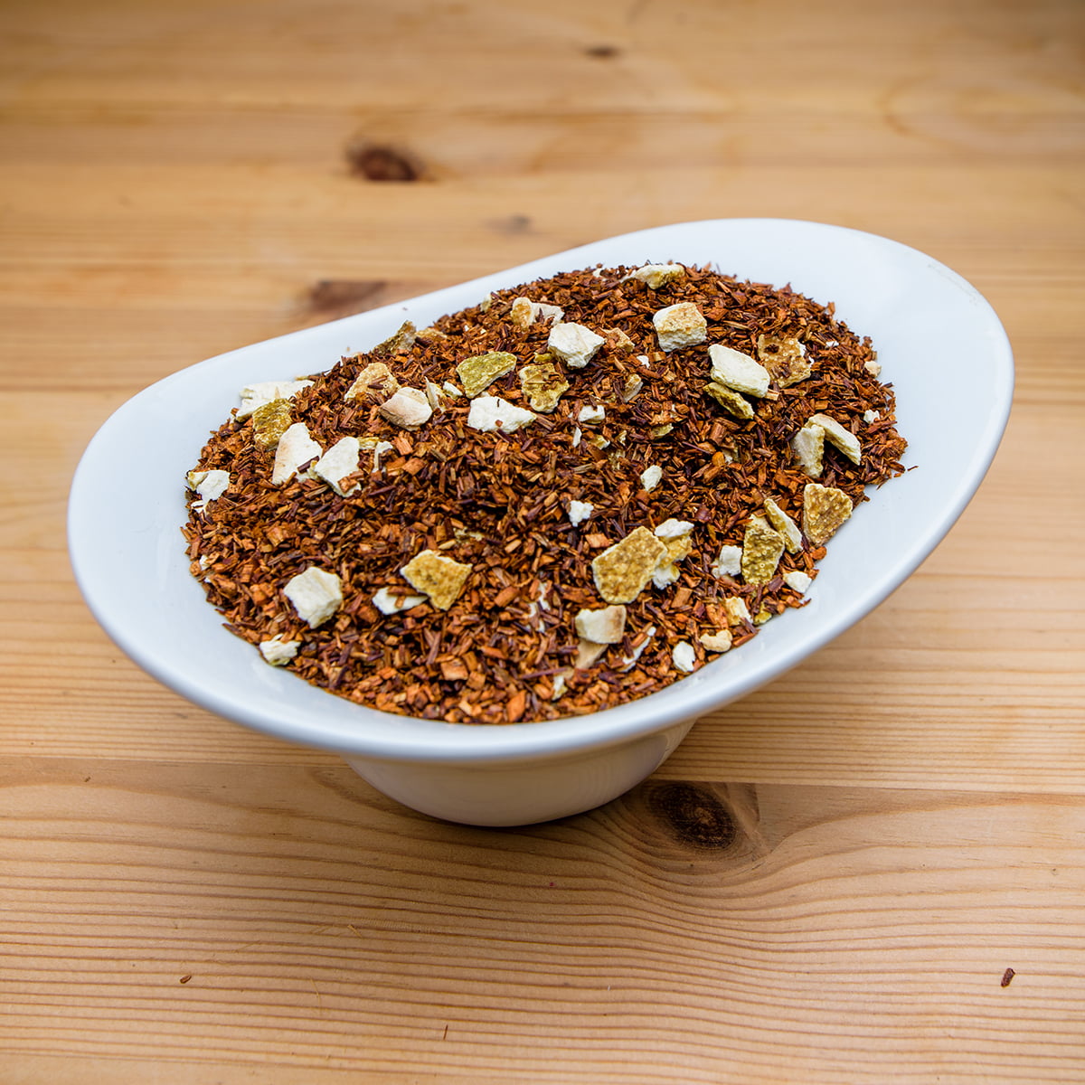 Cuenco de Rooibos de naranja ecológico sobre soporte de madera natural