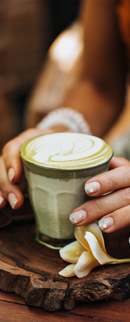 Mujer sujetando taza de té Matcha Ecológico con leche
