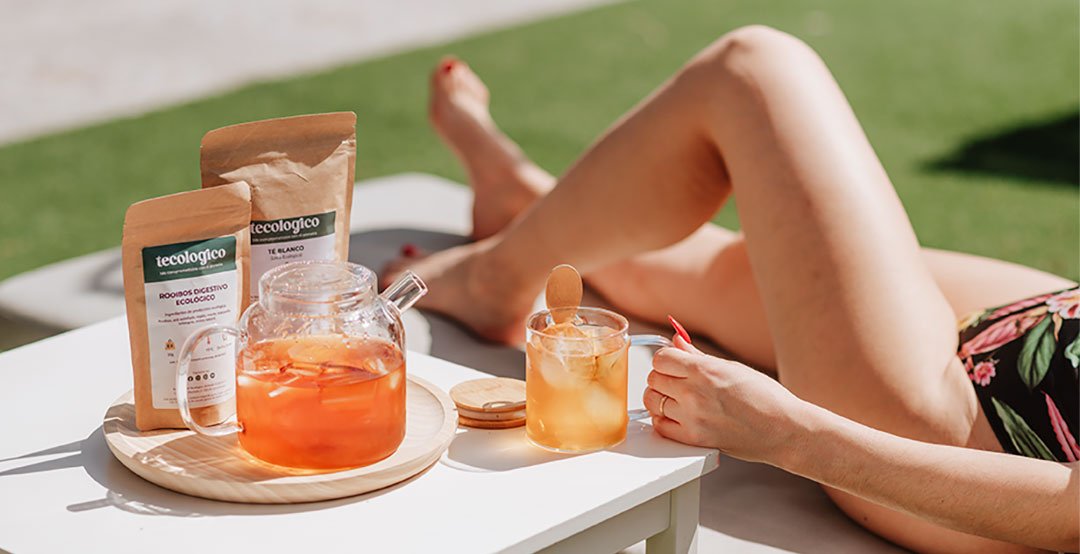 Mujer tomando el sol en la piscina y disfrutando de un té frio de tecológico.
